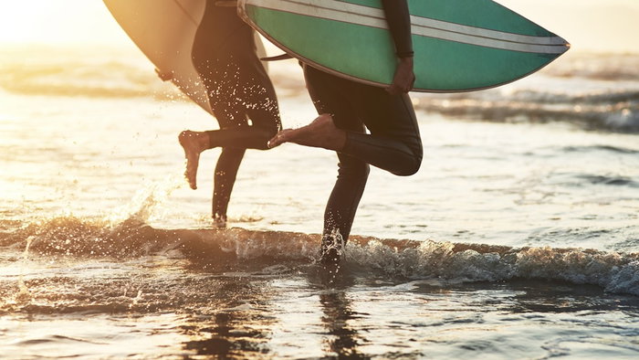 Surfers running towards the water