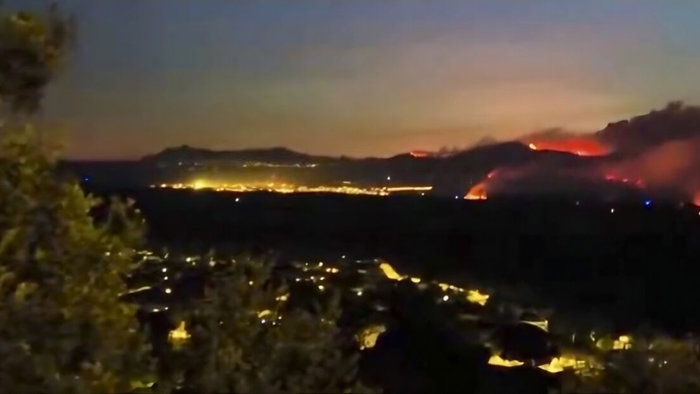 Hillside views of out of control wildfire approaching safari park in Madrid.