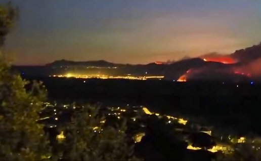 Hillside views of out of control wildfire approaching safari park in Madrid.