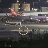 Errant wheel rolls away from Ryanair plane, chased by van.