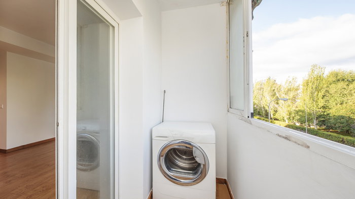 A washing machine installed on a narrow apartment balcony in Spain.