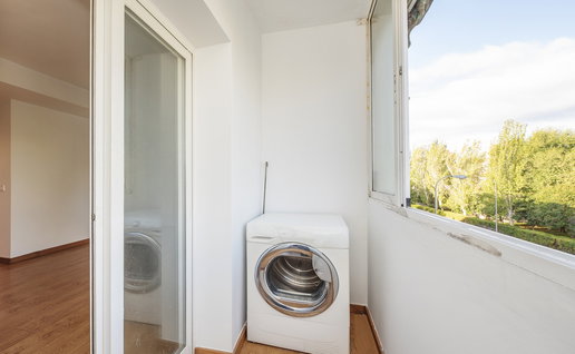 A washing machine installed on a narrow apartment balcony in Spain.