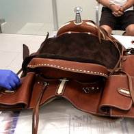 A western saddle with saddle bags attached being examined by police officers
