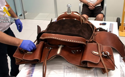 A western saddle with saddle bags attached being examined by police officers