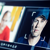 A facial recognition wireframe overlaid on a man's face next to a second, blurred portrait, illustrating AI-based identity manipulation.