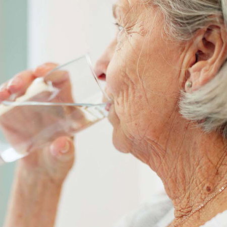 Healthy, hydration and senior woman drinking water for wellness and liquid diet detox at home.