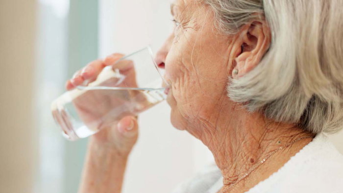 Healthy, hydration and senior woman drinking water for wellness and liquid diet detox at home.