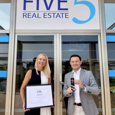 Outside of Five Real Estate offices with staff holding the award