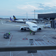 Workers next to a Ryanair flight on Barcelona airport runway.