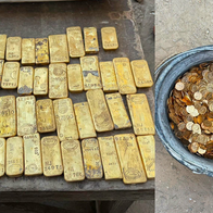 Gold bars laid out and a bucket bull of gold coins.