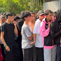 A tightly packed queue of young migrants standing behind metal barriers in Ceuta.