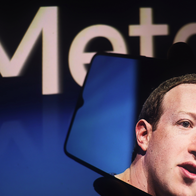 Mark Zuckerberg picture on a phone in front of a Meta sign.
