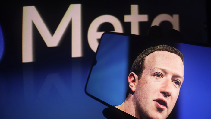 Mark Zuckerberg picture on a phone in front of a Meta sign.