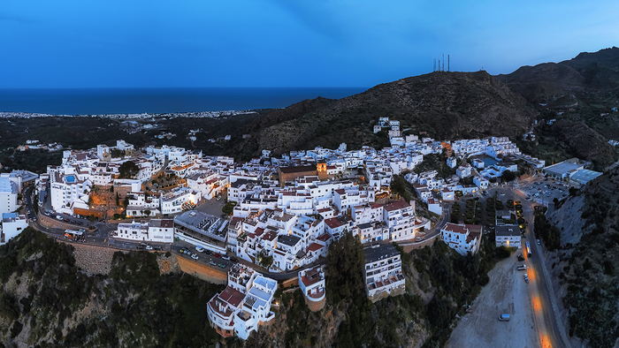 Aerial night view of Mojácar's hillside town lit up above the Almería coastline