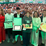 Winners and officials pose on stage at the Cabrales cheese contest awards ceremony.