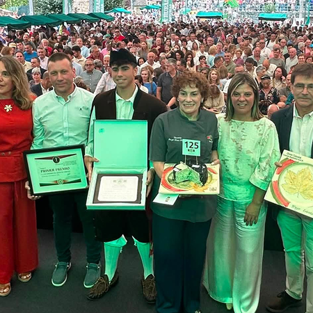 Winners and officials pose on stage at the Cabrales cheese contest awards ceremony.