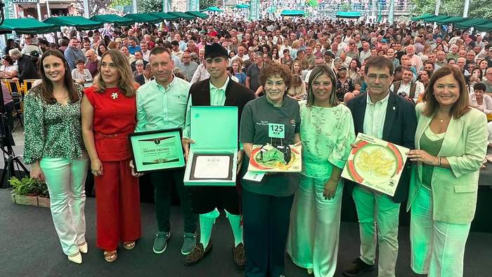 Winners and officials pose on stage at the Cabrales cheese contest awards ceremony.
