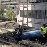 Car topples off bridge and into way of trains.