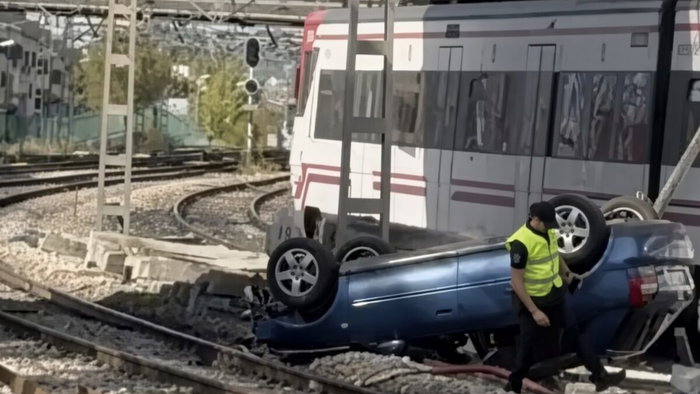 Car topples off bridge and into way of trains.