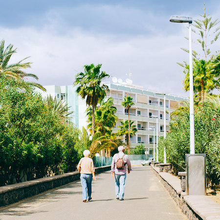 Two pensioners walking down a footpath in Spain