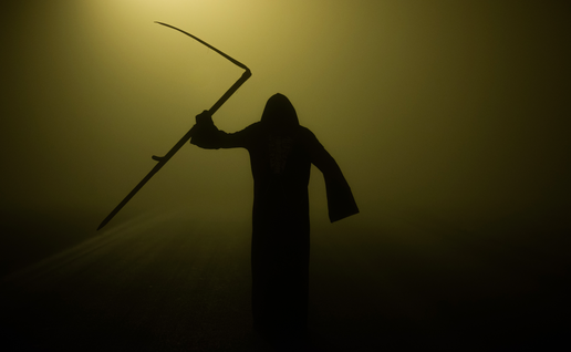 A dark figure dressed as the grim reaper coming out from the fog