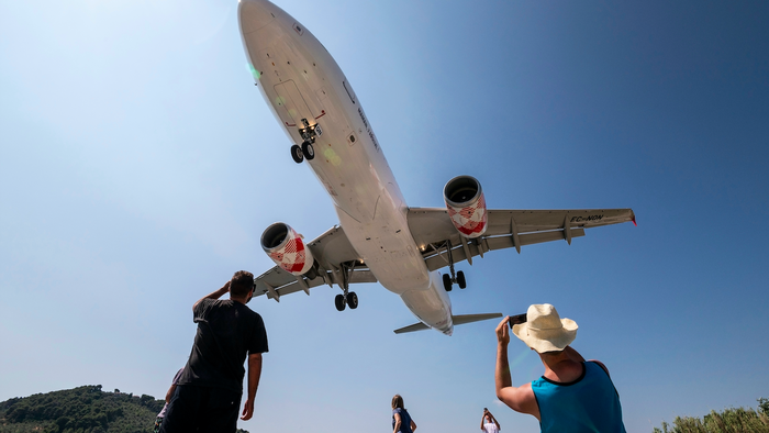People watch and take photos of a Volotea Airbus A320 (EC-NQN) as it lands