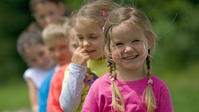 children in a garden staring at the camera