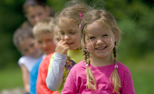 children in a garden staring at the camera