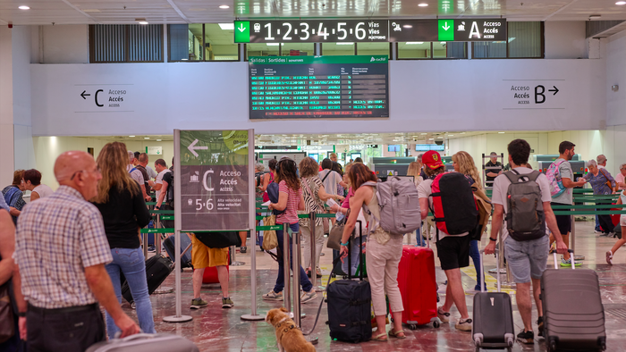 Passengers queue at El Prat airport in Barcelona.