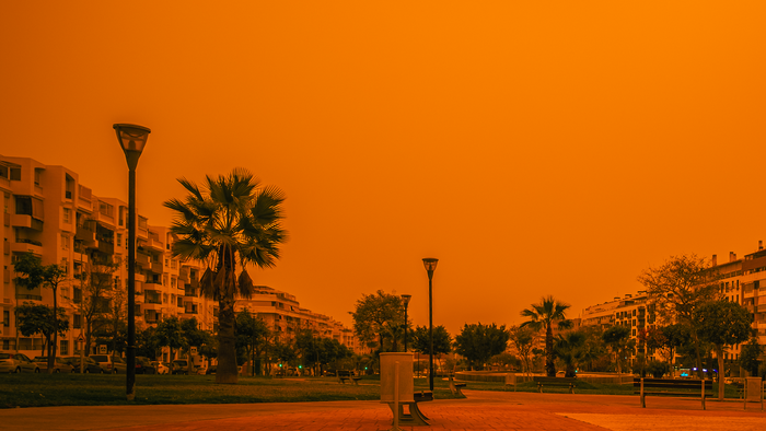 A village with a red sky caused by Saharan Sand