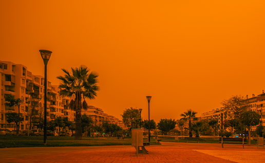 A village with a red sky caused by Saharan Sand