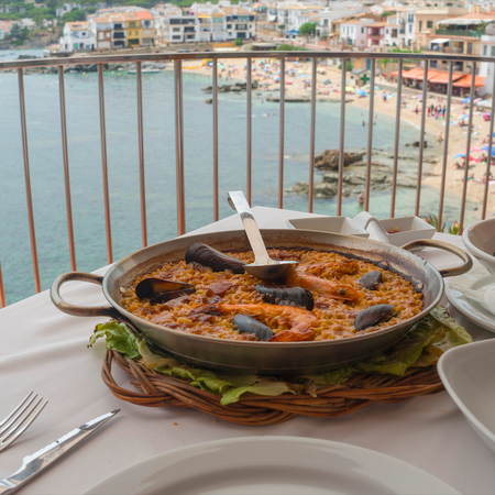 A traditional paella at a beach front restaurant accompanied with a bowl of mussels