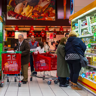 Shoppers with their trolleys in a refrigerate aisle of a supermarket