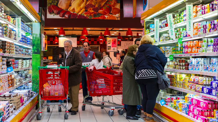 Shoppers with their trolleys in a refrigerate aisle of a supermarket