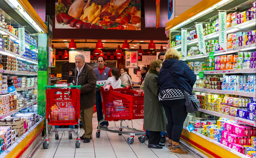 Shoppers with their trolleys in a refrigerate aisle of a supermarket