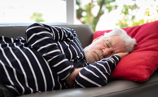 Elderly man sleeping on a sofa.