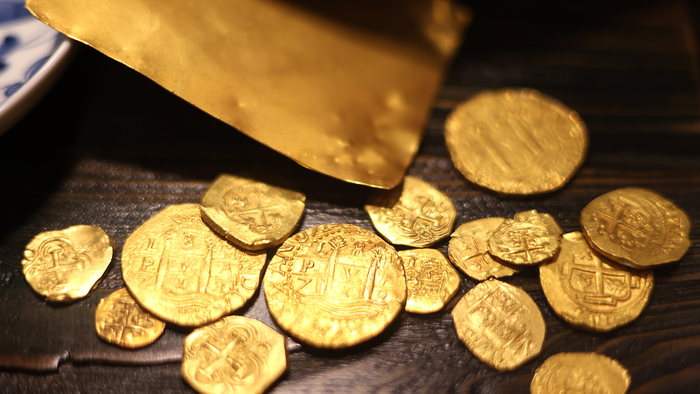 Gold coins spread out on a table.