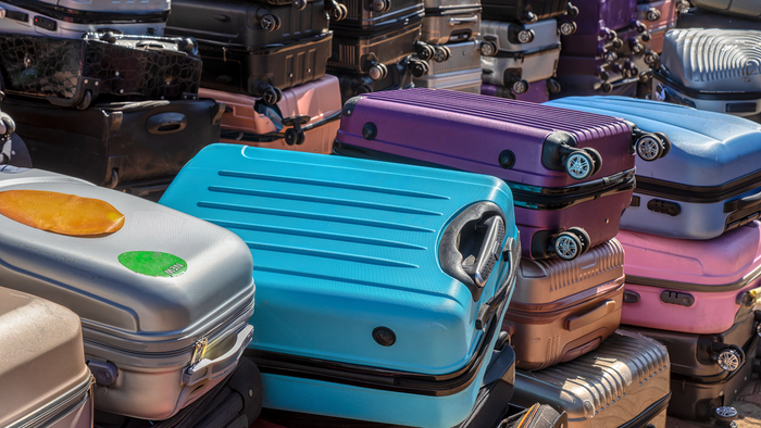 Many suitcases piled up one on top of another.