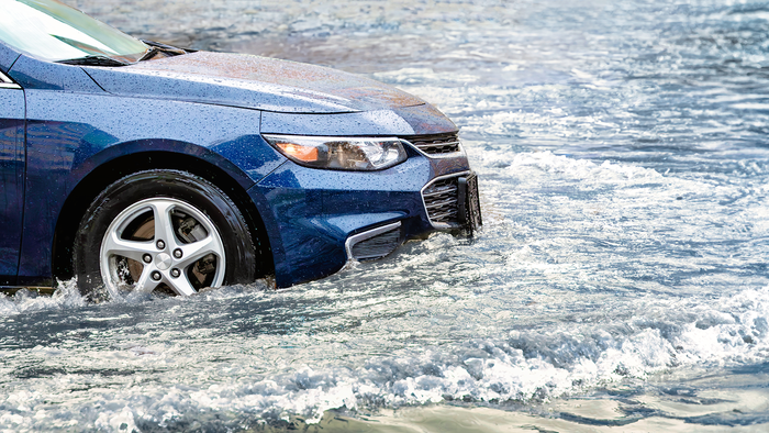 A car driving through floodwater on a road