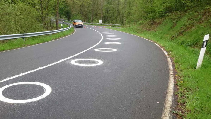 White circles painted on the curve of the road to improve motorcycle safety