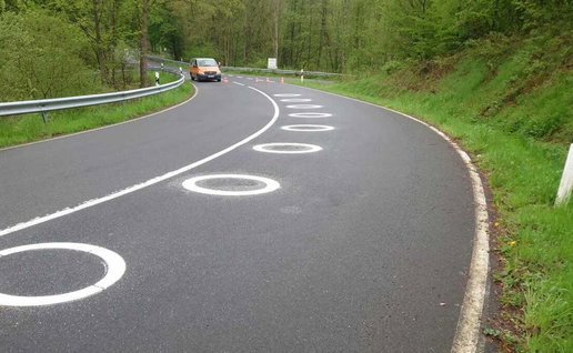 White circles painted on the curve of the road to improve motorcycle safety