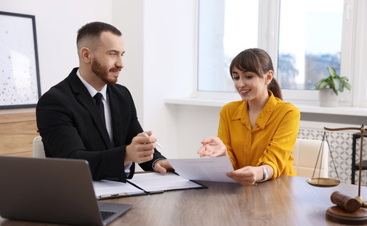 Woman having meeting with professional lawyer at wooden desk indoors