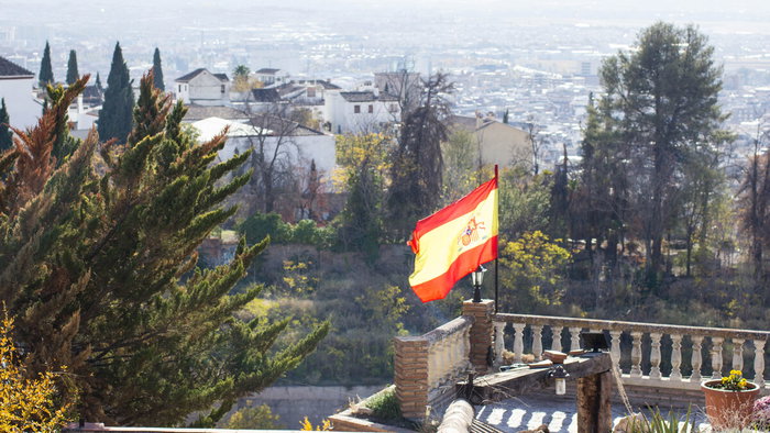 Spanish flag blowing in wind in Granada