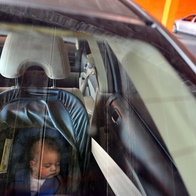 A baby left inside a car alone.