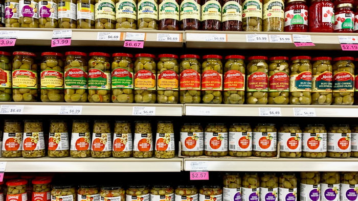 Several jars Of Pickled Olives on a grocery store shelf