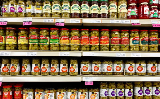 Several jars Of Pickled Olives on a grocery store shelf