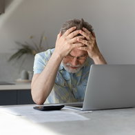 Man frustrated looking at his bank account