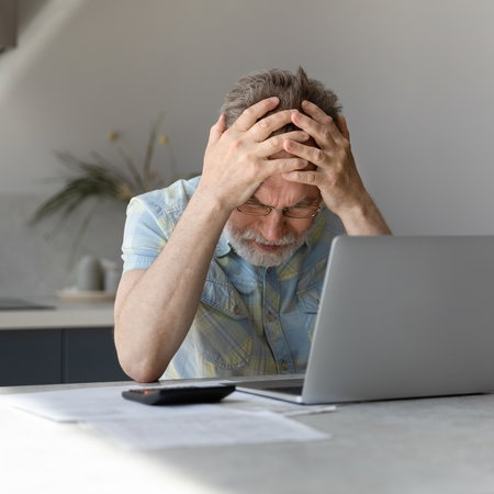 Man frustrated looking at his bank account
