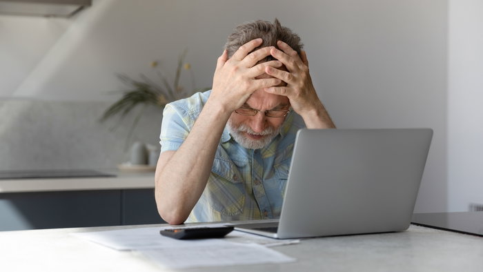 Man frustrated looking at his bank account