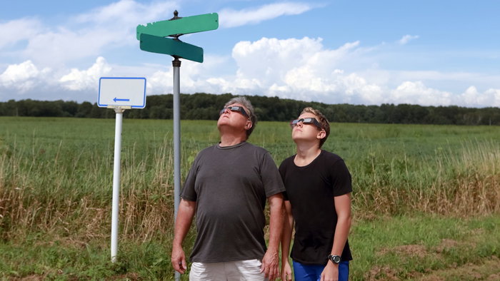 two people looking up at a solar eclipse with protective glasses
